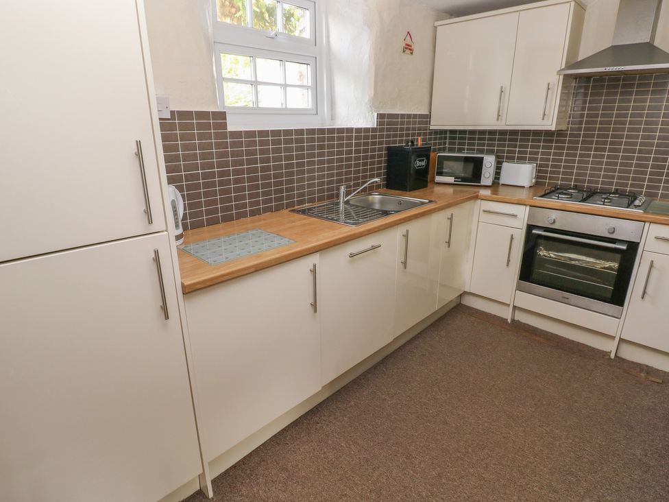 A kitchen with cabinets and appliances at Stable Cottage in Clarbeston Road
