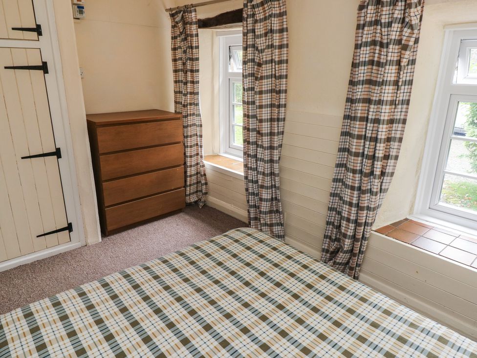 A bedroom with a bed and a dresser at Stable Cottage Clarbeston Road
