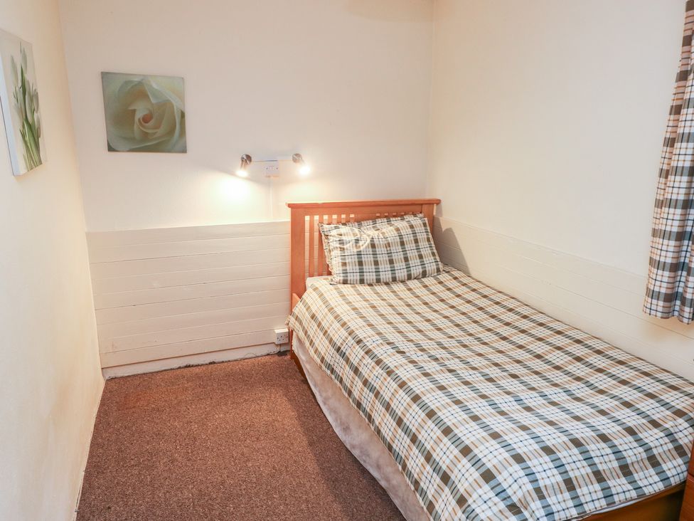 A bedroom with a single bed and wall art at Stable Cottage in Clarbeston Road