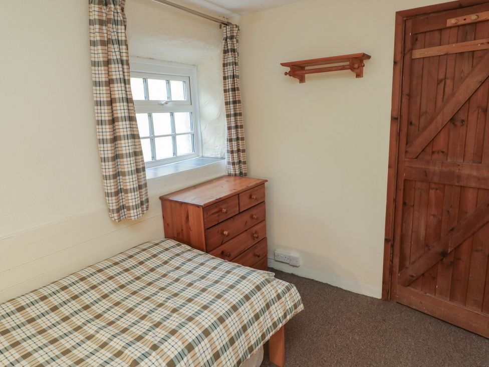 A bedroom with a bed, chest of drawers, and window at Stable Cottage in Clarbeston Road
