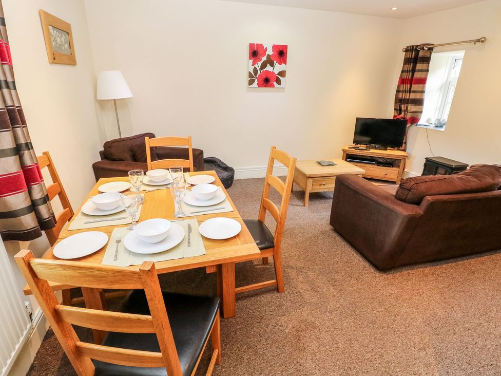 A dining area with a table set for meals at Swallows Cottage in Clarbeston Road