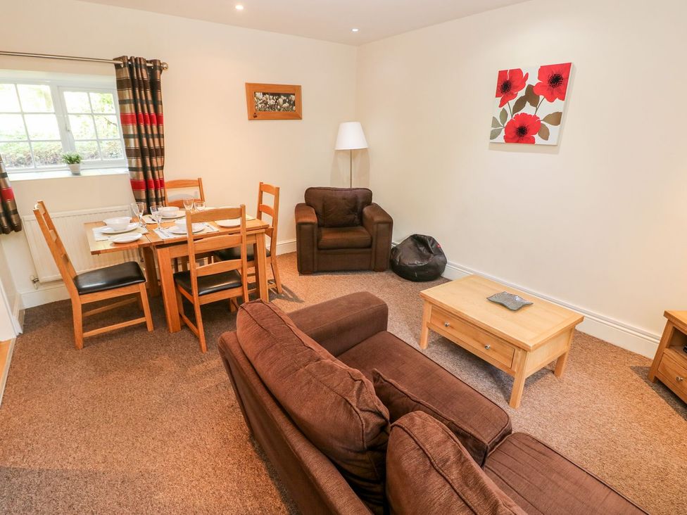 A living room with a table and chairs at Swallows Cottage in Clarbeston Road