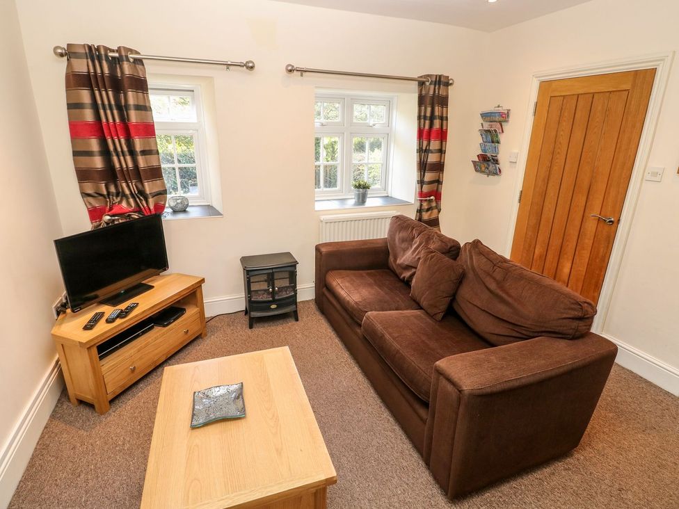 A living room with a sofa and television at Swallows Cottage in Clarbeston Road