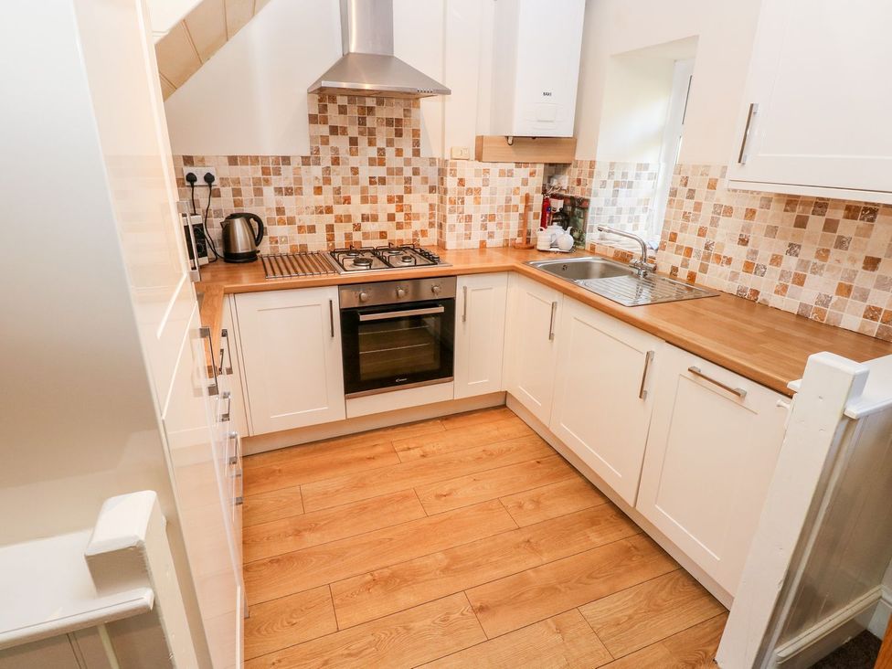 A kitchen with stove and sink at Swallows Cottage in Clarbeston Road