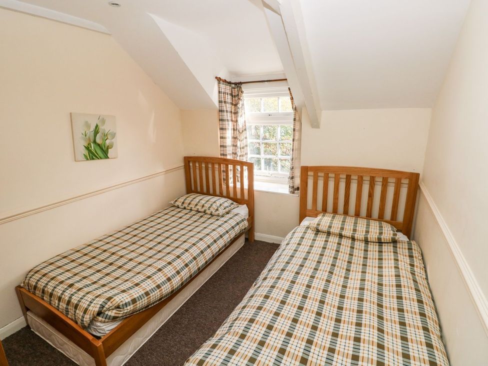A bedroom with two beds and a window at Swallows Cottage in Clarbeston Road