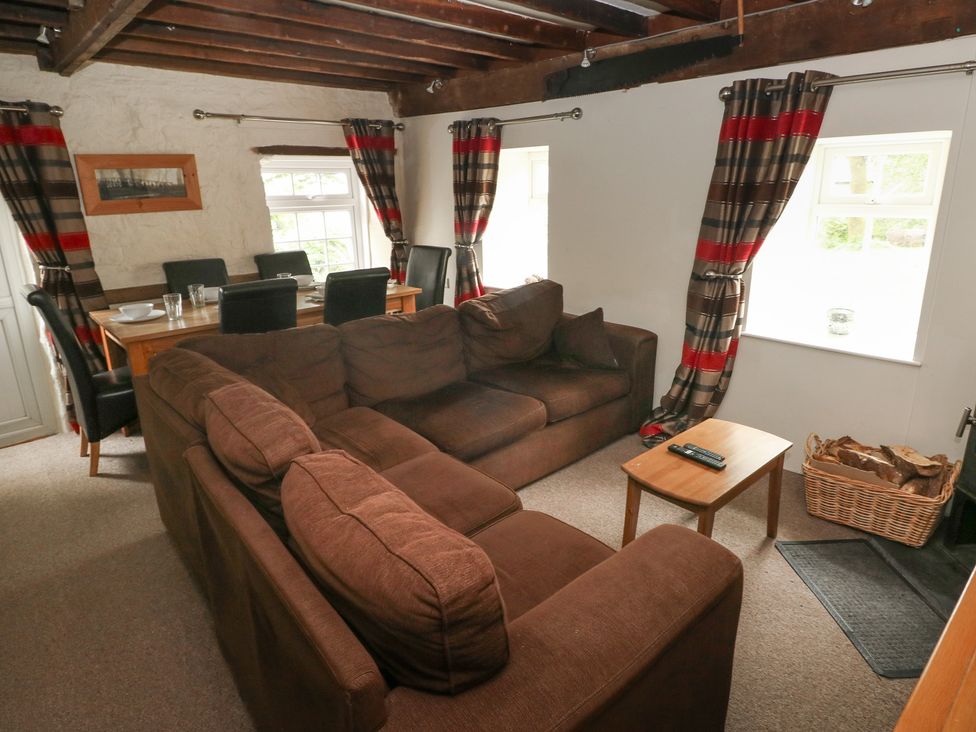 A living room with a sofa and dining area at Shippen Cottage in Clarbeston Road