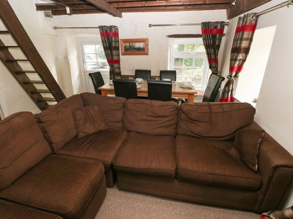A living room with a sofa and dining table at Shippen Cottage in Clarbeston Road