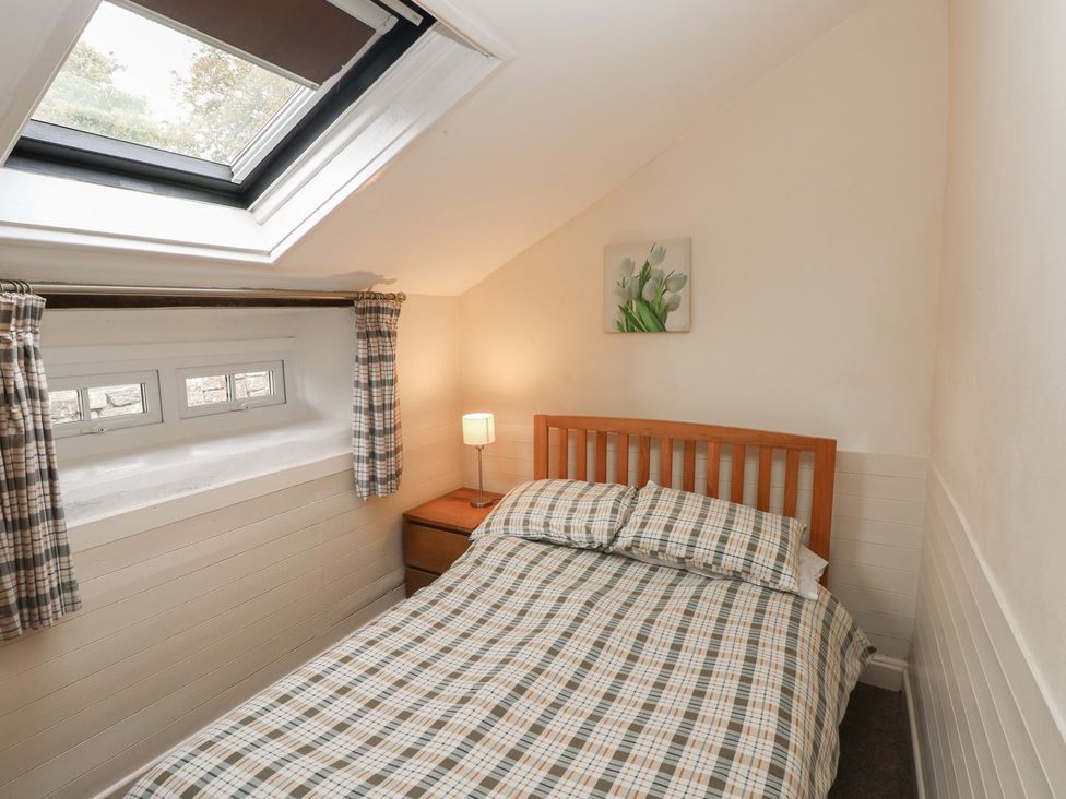 A bedroom with a bed and a lamp at Shippen Cottage in Clarbeston Road
