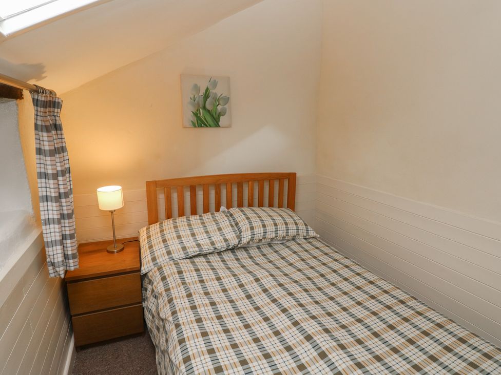 A bedroom with a bed and lamp at Shippen Cottage in Clarbeston Road