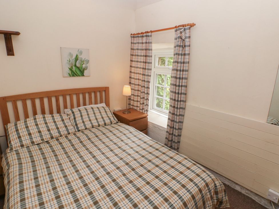 A bedroom with a bed and nightstand at Shippen Cottage in Clarbeston Road
