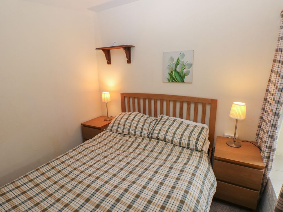A bedroom with a bed and nightstand at Shippen Cottage in Clarbeston Road