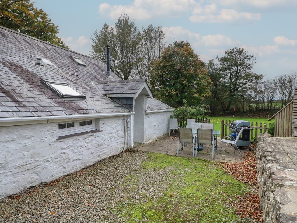 A garden area with a table and chairs at Shippen Cottage in Clarbeston Road