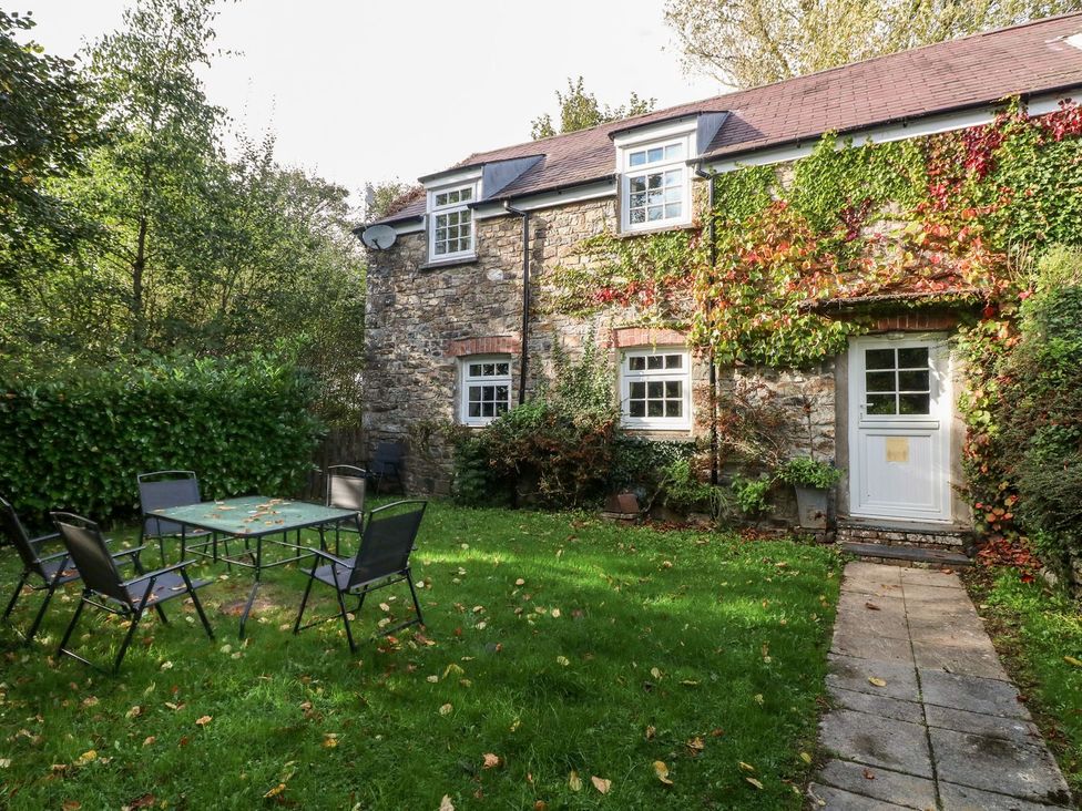A garden with a table and chairs at Lake Cottage in Clarbeston Road