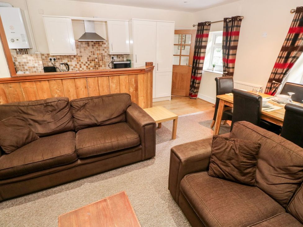 A living room with sofas and a dining area at Lake Cottage in Clarbeston Road