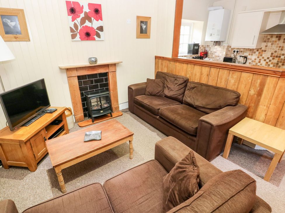 A living room with a television and sofa at Lake Cottage in Clarbeston Road