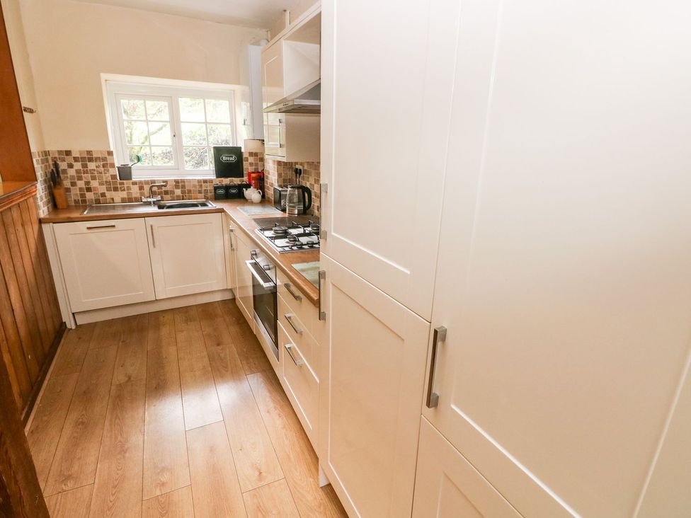 A kitchen with cabinetry and appliances at Lake Cottage in Clarbeston Road