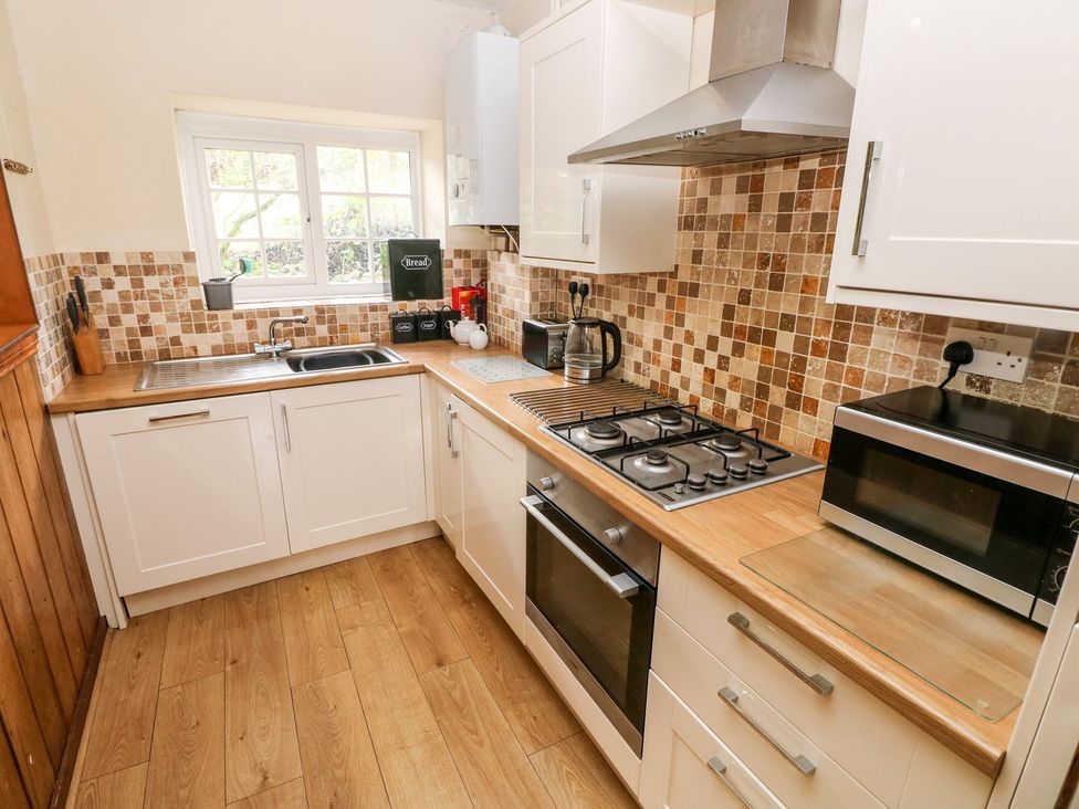 A kitchen with cabinets and appliances at Lake Cottage in Clarbeston Road