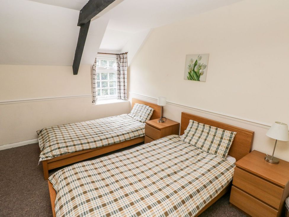 A bedroom with twin beds and nightstands at Lake Cottage in Clarbeston Road