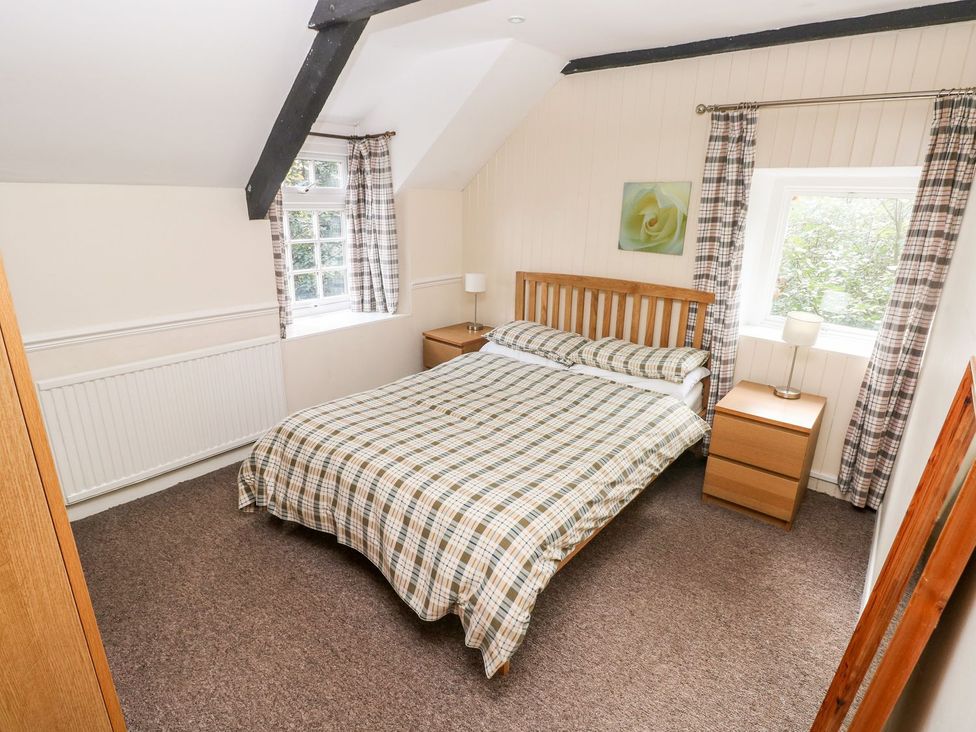 A bedroom with a bed and nightstands at Lake Cottage in Clarbeston Road