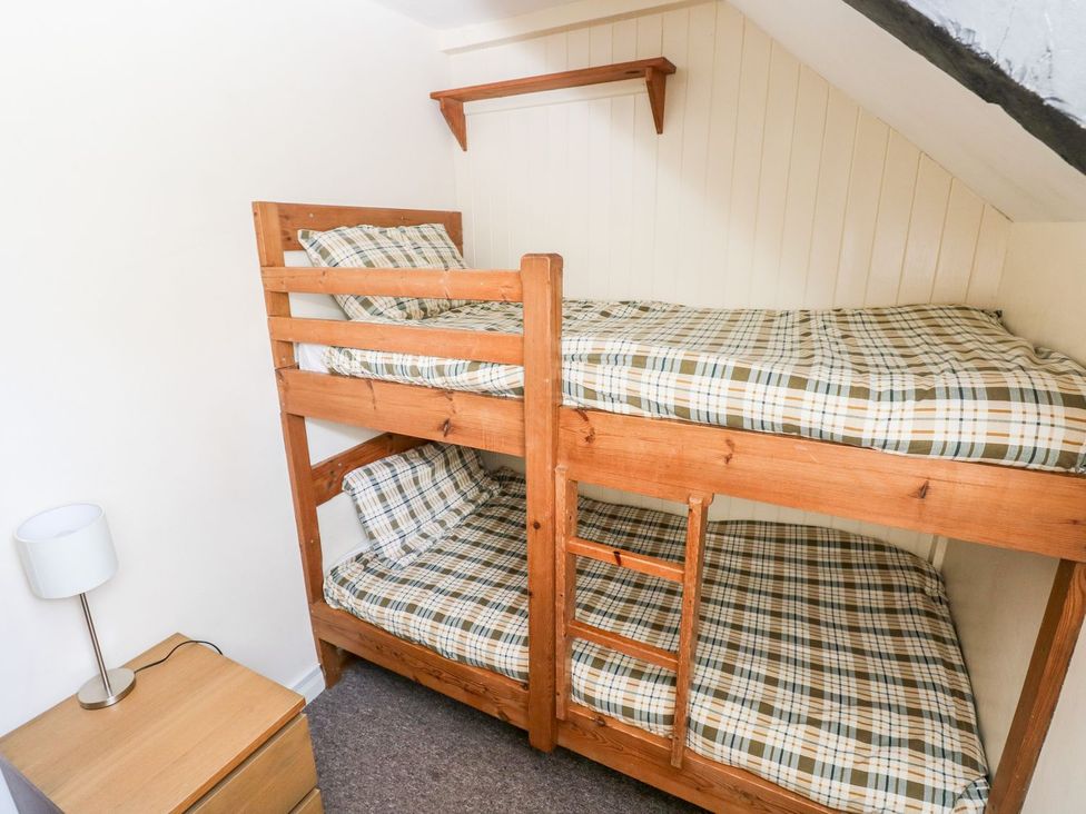 A bedroom with a bunk bed and furniture at Lake Cottage in Clarbeston Road
