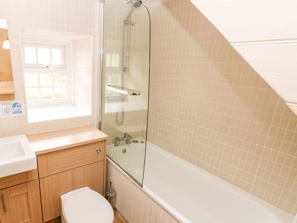 A bathroom with a bathtub and shower at Lake Cottage in Clarbeston Road