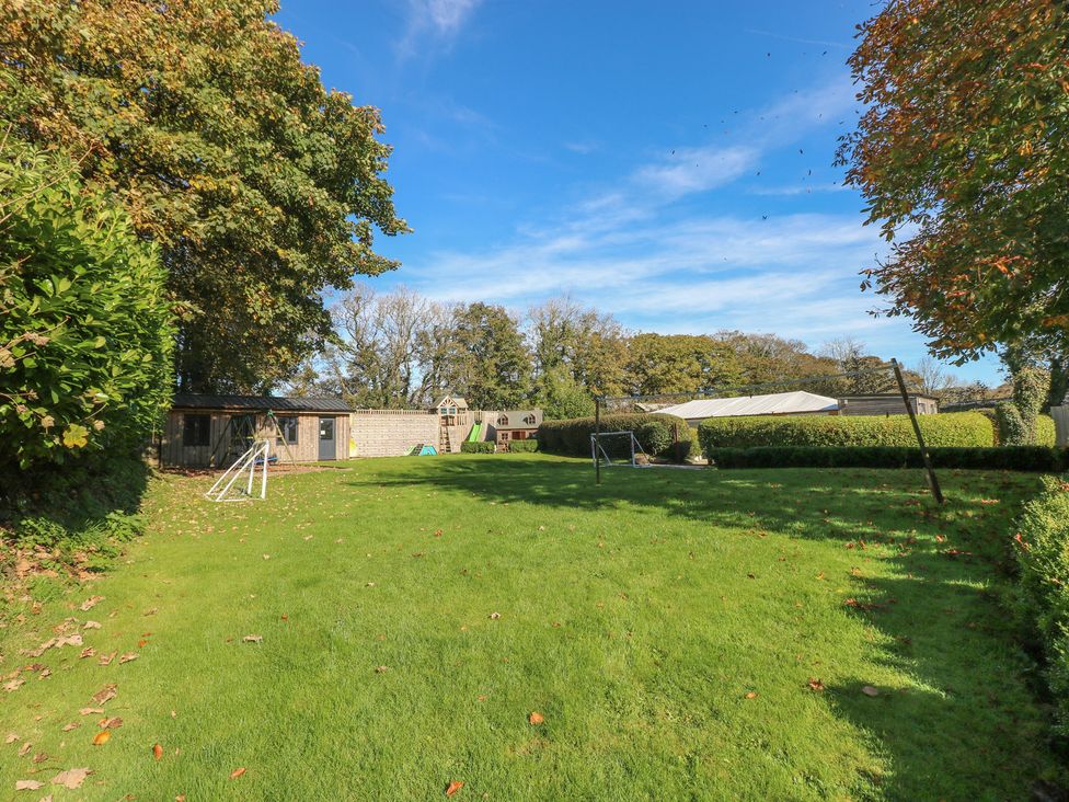 A garden with a slide and swing at Lake Cottage in Clarbeston Road