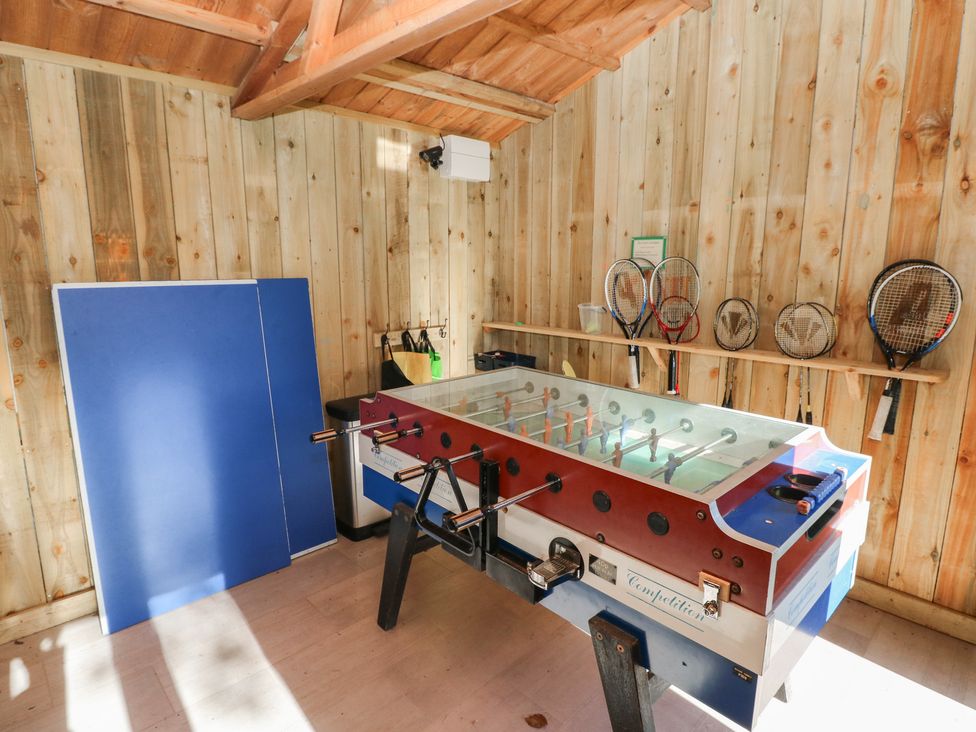 A game room with a foosball table and tennis rackets at Lake Cottage Clarbeston Road