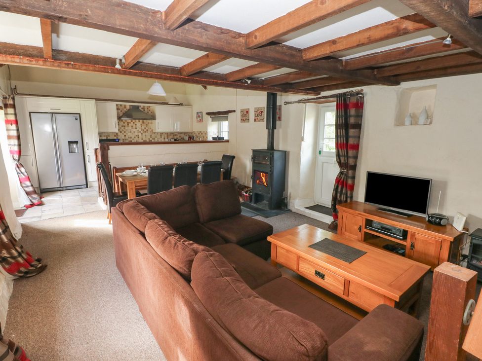 A living room with a sofa and dining area at Granary Cottage, Clarbeston Road