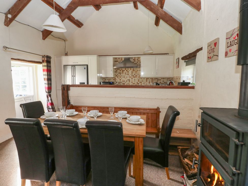 A dining room with a table set for dinner at Granary Cottage in Clarbeston Road