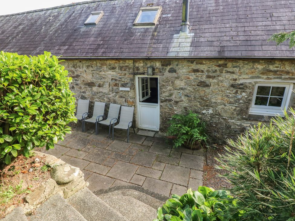 An outdoor patio area with chairs and plants at Granary Cottage in Clarbeston Road