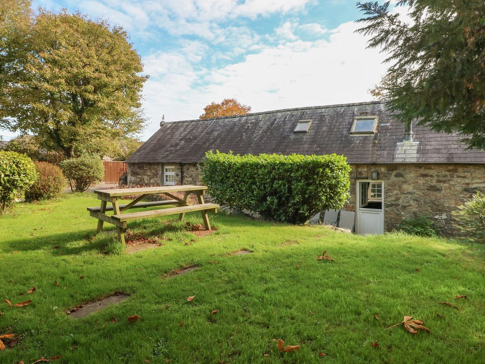 A garden area with a picnic table and bushes at Granary Cottage in Clarbeston Road