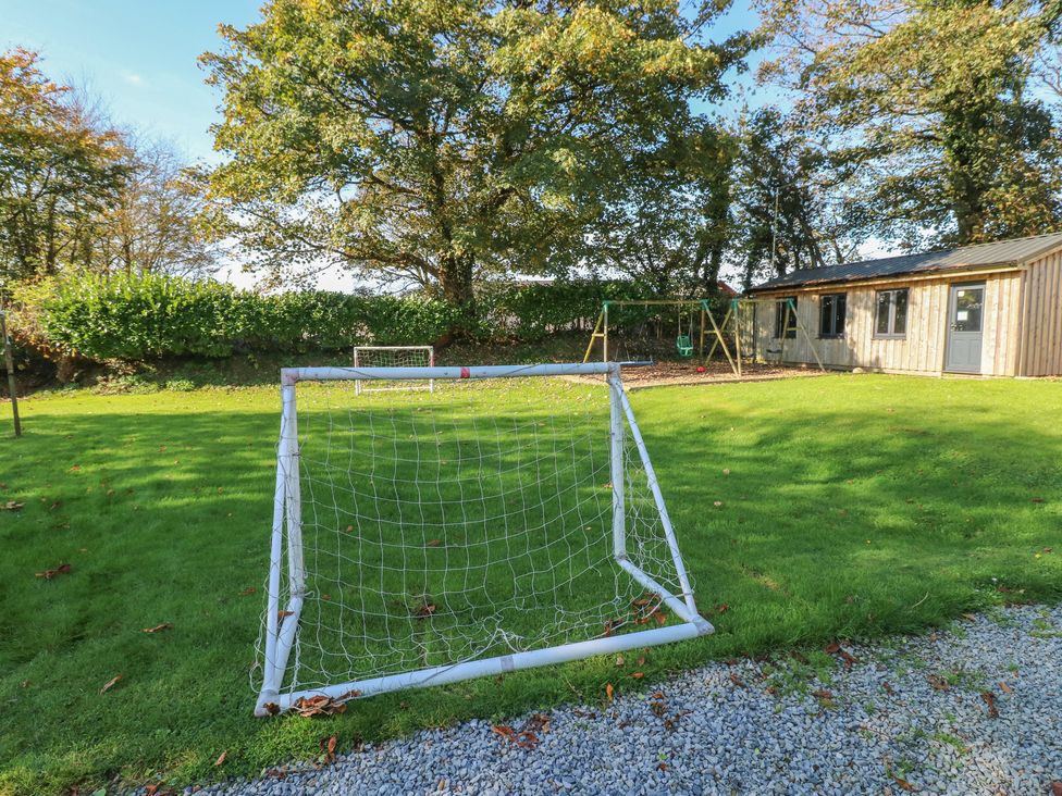 A garden with a soccer goal and swing set at Granary Cottage in Clarbeston Road