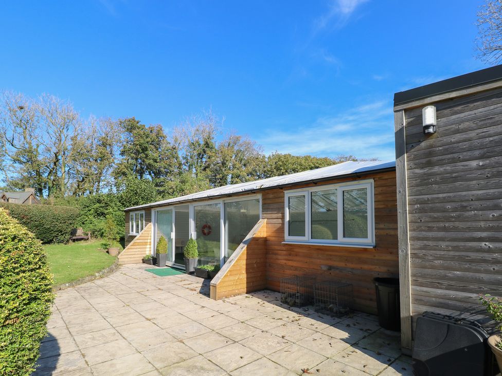 An outdoor area with a patio and windows at Granary Cottage in Clarbeston Road