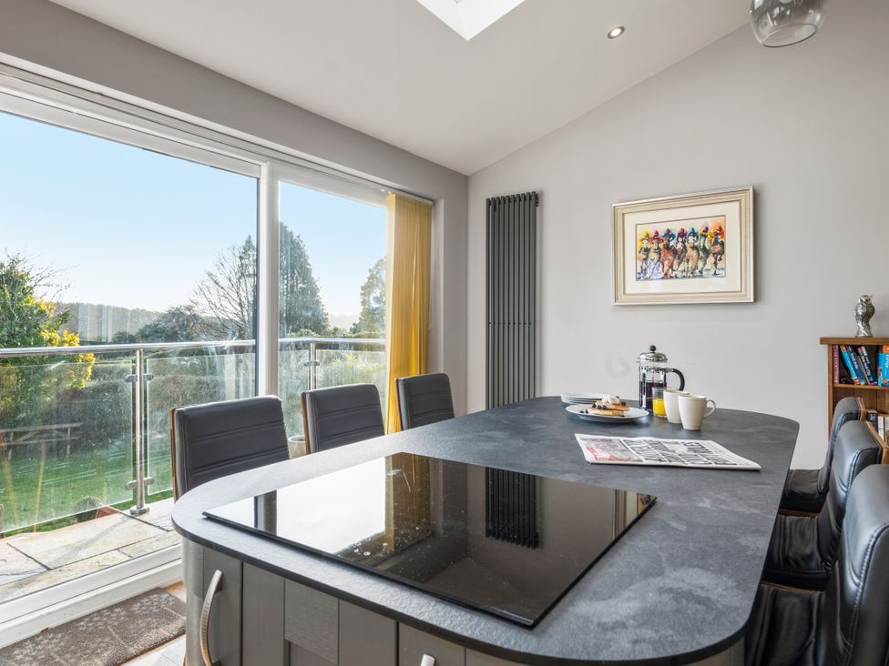 A kitchen with a table and chairs at Newlands in Yelverton