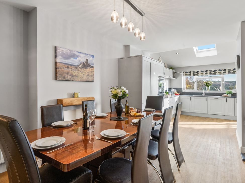 A dining room with a table and chairs at Newlands in Yelverton