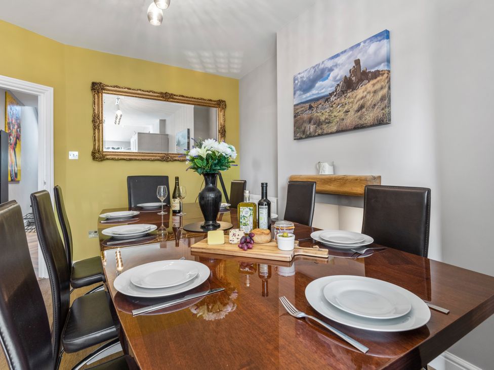 A dining room with a table set for meals at Newlands in Yelverton