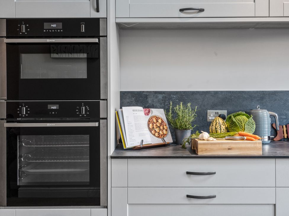 A kitchen with ovens and a variety of vegetables at Newlands in Yelverton
