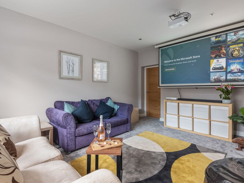 A living room with a projector and sofa at Newlands in Yelverton