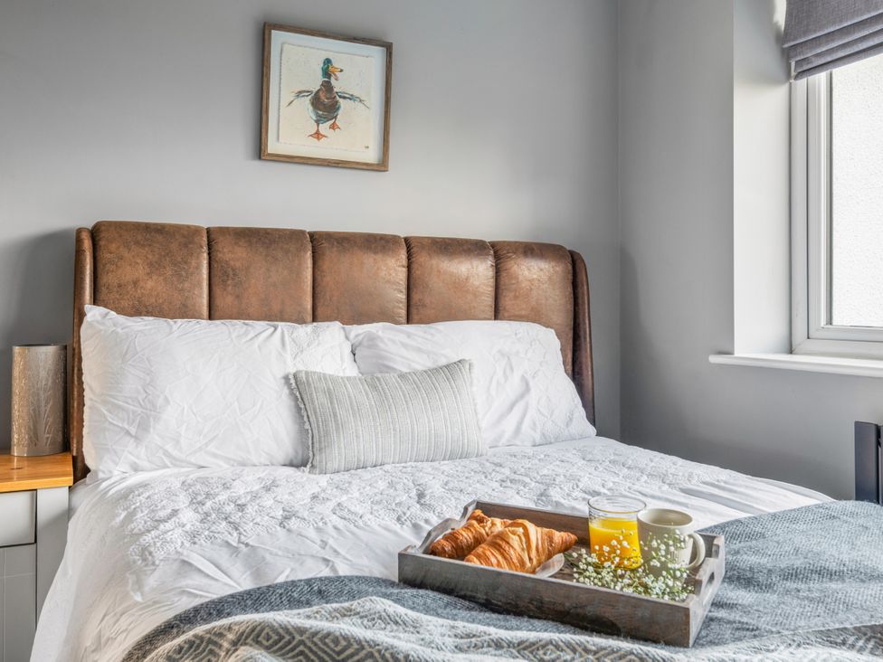 A bedroom with a bed and a tray with drinks and croissants at Newlands Yelverton