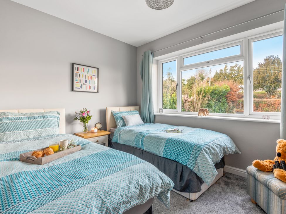 A bedroom with two beds and a tray on the table at Newlands in Yelverton