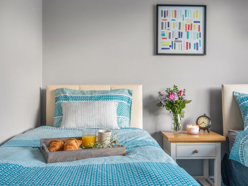 A bedroom with two beds and a tray of breakfast items at Newlands in Yelverton