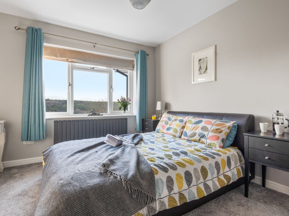 A bedroom with a bed and window at Newlands in Yelverton