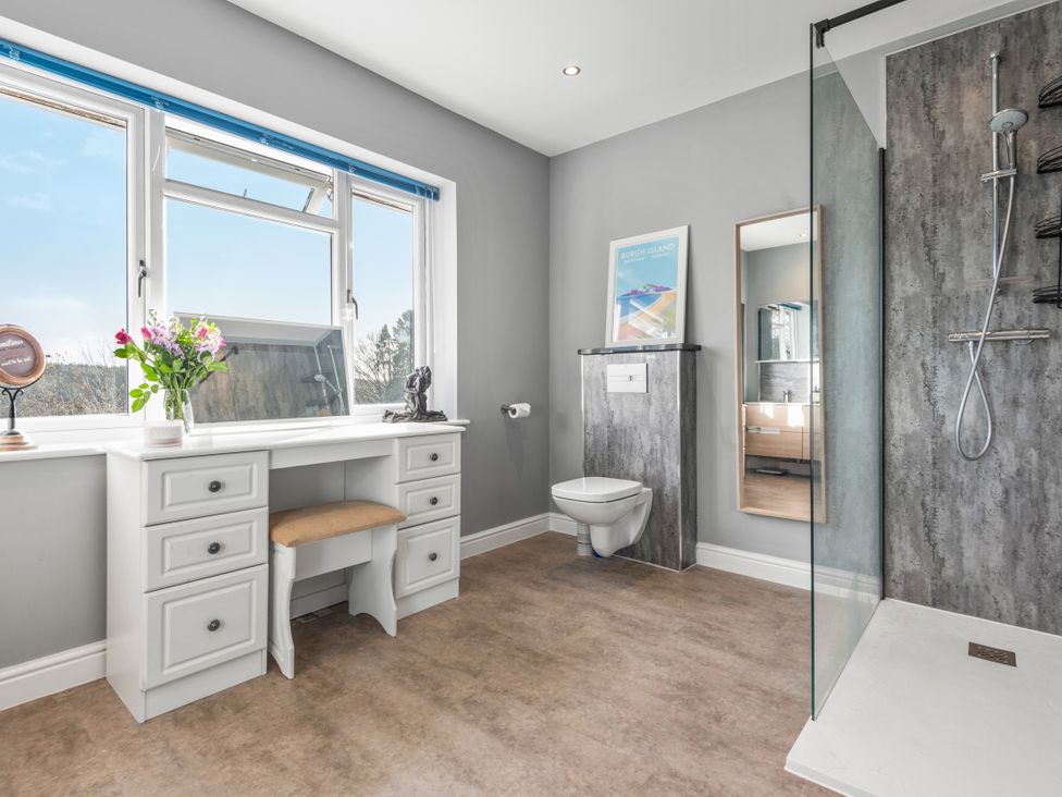 A bathroom with a shower and a desk at Newlands in Yelverton