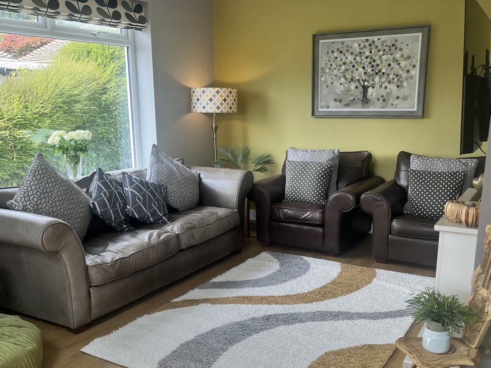 A living room with a sofa and two armchairs at Newlands in Yelverton