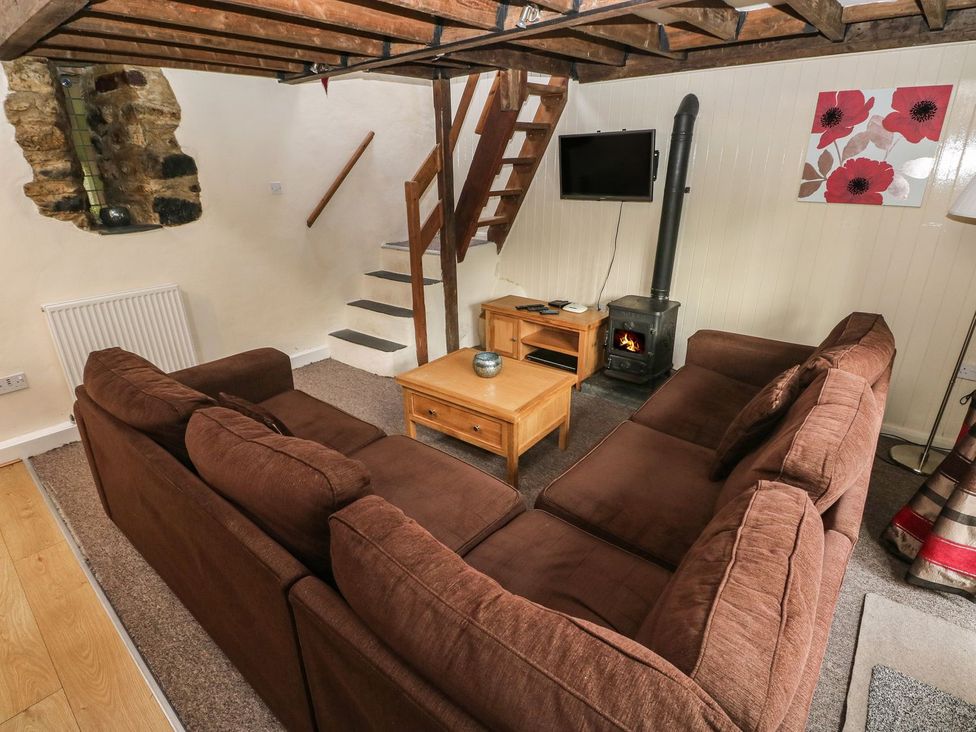 A living room with a sofa and a coffee table at Rafters Cottage in Clarbeston Road