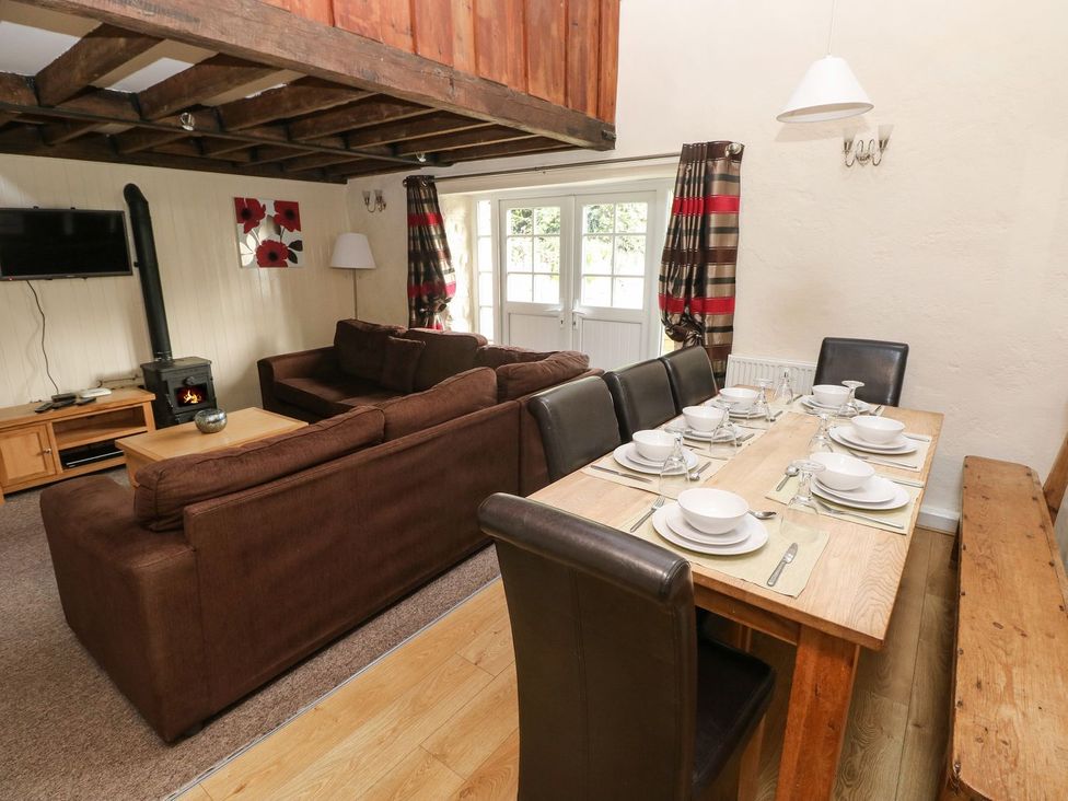 A living room with a dining table and sofa at Rafters Cottage in Clarbeston Road