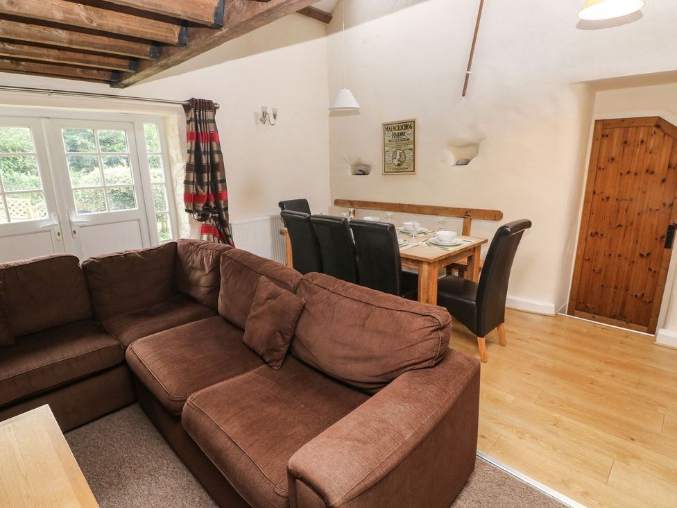A living room with a sofa and dining area at Rafters Cottage Clarbeston Road
