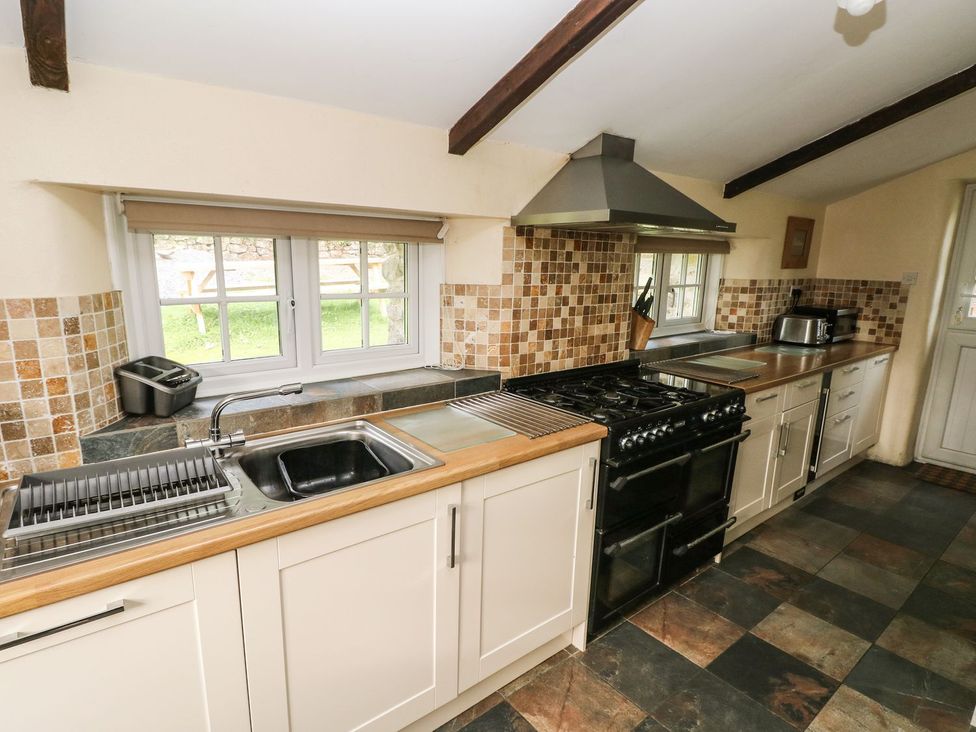 A kitchen with a sink and stove at Rafters Cottage in Clarbeston Road