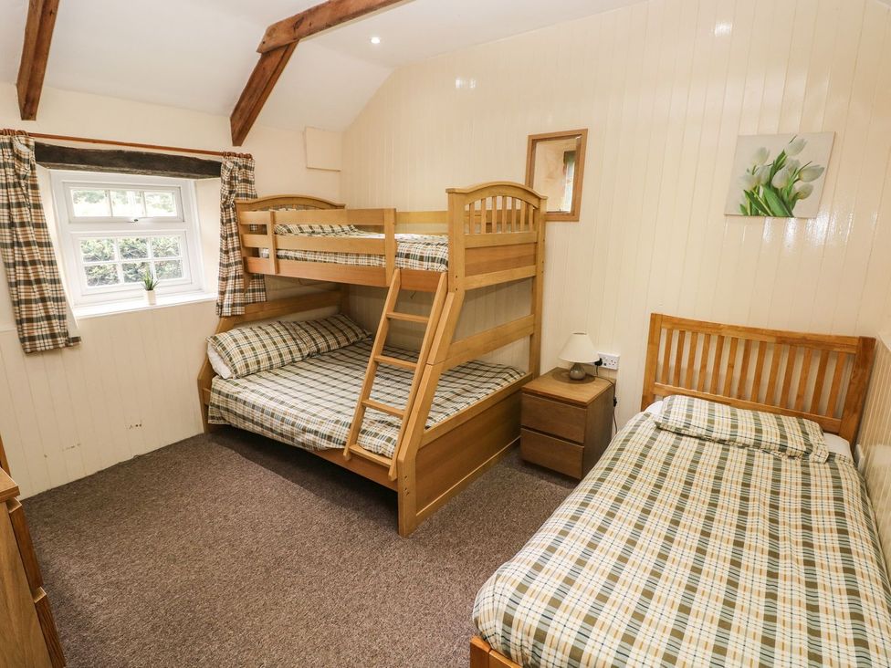 A bedroom with a bunk bed and a single bed at Rafters Cottage in Clarbeston Road