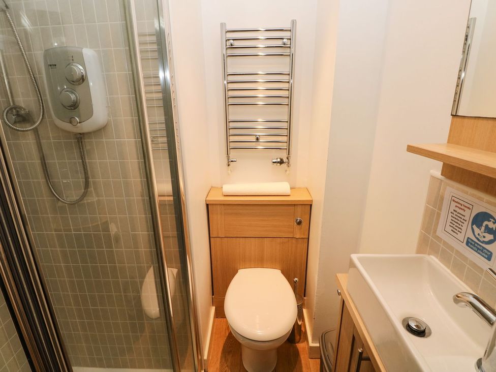 A bathroom with a shower, toilet and sink at Rafters Cottage in Clarbeston Road